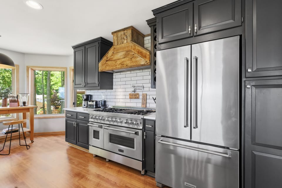 The chef-style kitchen at Beech Mountain High is fully equipped and beautifully lit — premium appliances and an abundance of natural light make cooking for the whole group as enjoyable as the meals themselves.