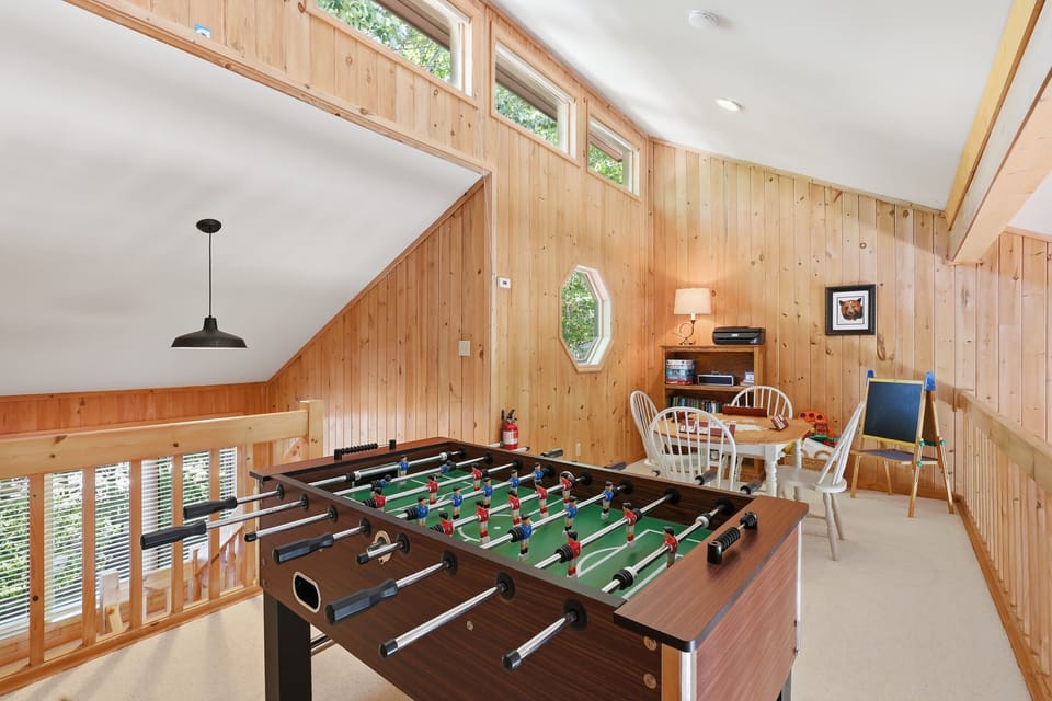 The bright wood-paneled loft is where family fun takes center stage — challenge everyone to a foosball match, gather for games, and enjoy a cheerful space that keeps the whole group entertained.