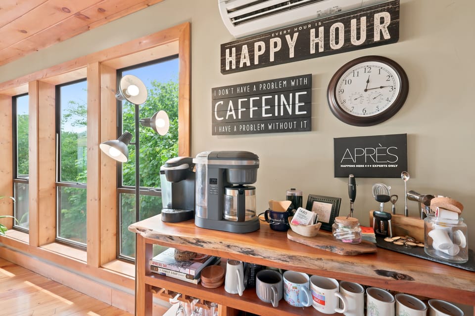 The rustic kitchen impresses with dramatic vaulted beams, gorgeous forest views, and a charming coffee bar — a beautifully designed space that makes cooking and morning coffee a true highlight at Beech Mountain Place.