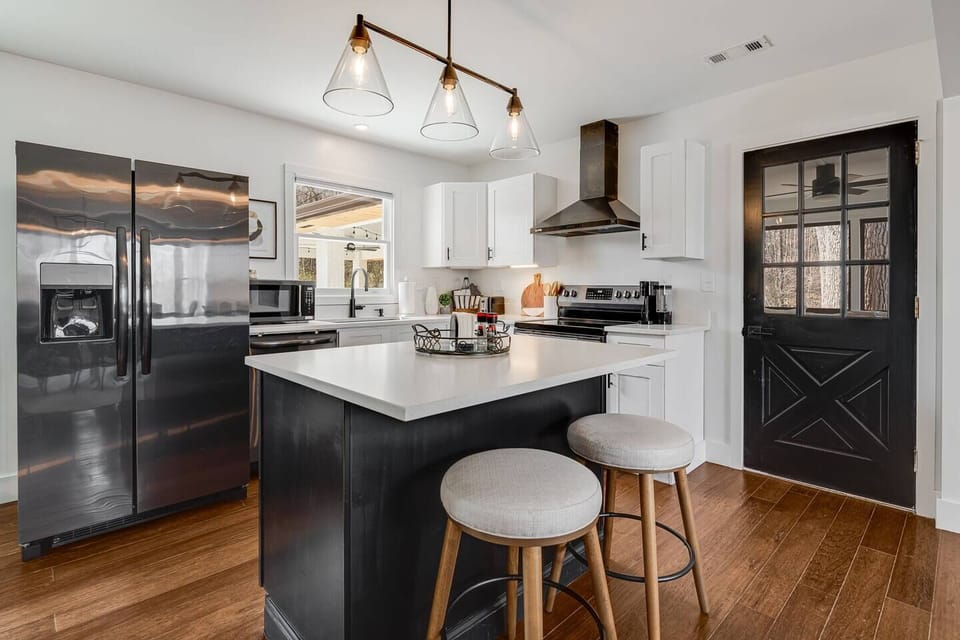 🍳 Fully equipped kitchen with a center island, quartz countertops, stainless appliances, and everything you need to cook for the whole group. Bright, open, and connected to the dining area — no takeout required. 🖤✨