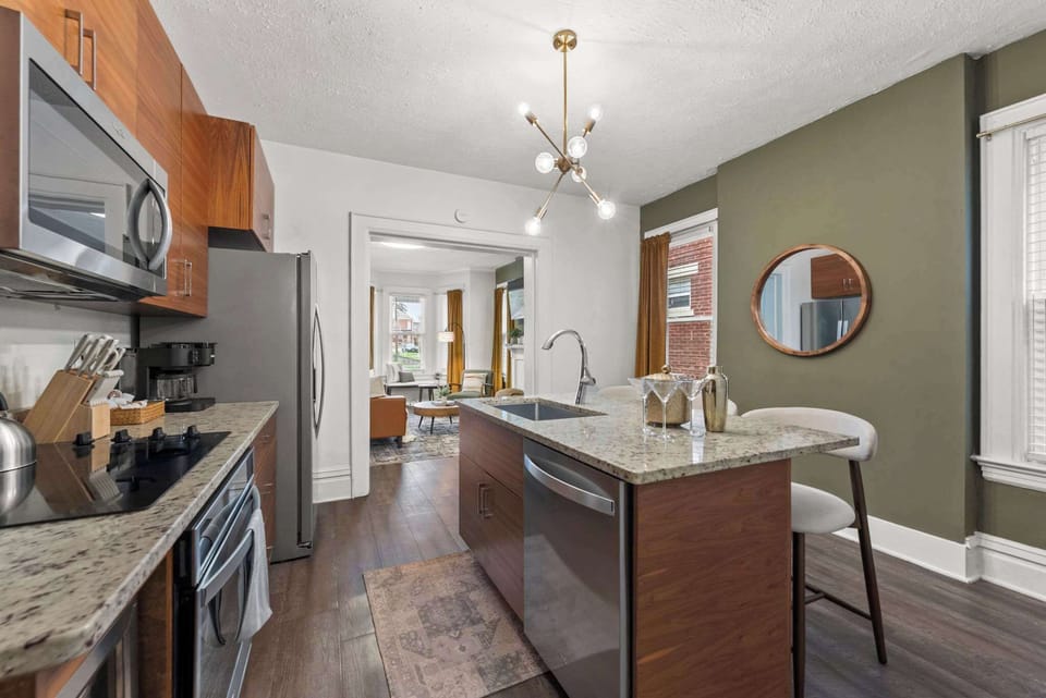 Kitchen island w/ pendant lighting, ideal for prepping meals or casual bites.