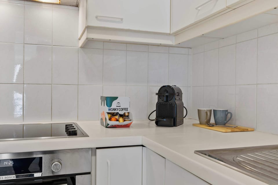 Bright kitchen with a cooktop, coffee machine and plenty of counter space, fully equipped for self-catering in this stylish 2-bedroom apartment in Knokke.