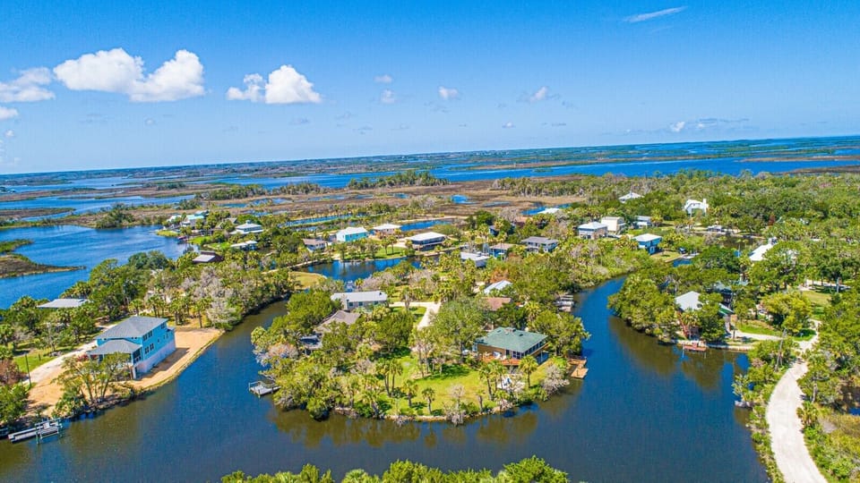 Exterior of home with water views, fire pit, water views, & dock