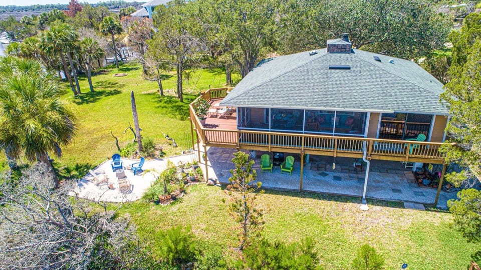 Exterior of home with water views, fire pit, water views, & dock