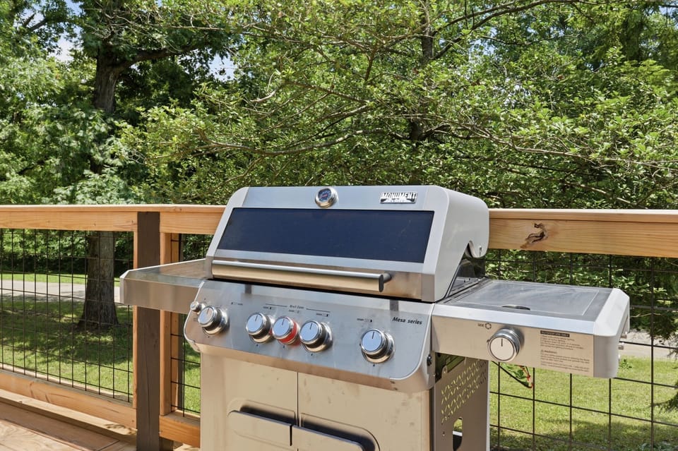 Large gas grill on a private deck surrounded by peaceful greenery