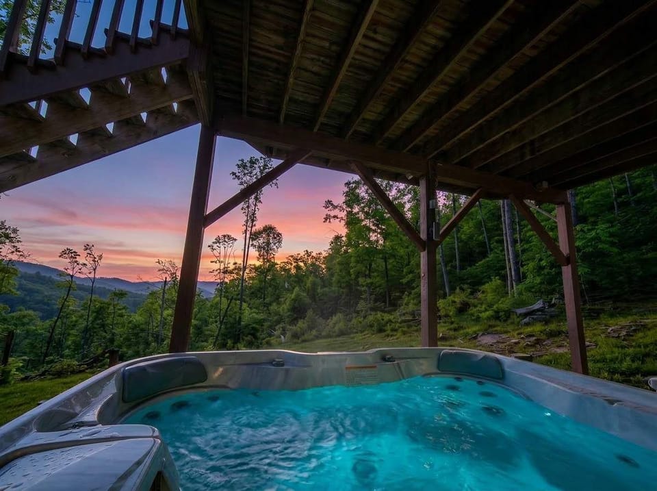 A bubbling hot tub, an open-air pergola, and a sky full of color over the peaks — your most memorable soak yet awaits.