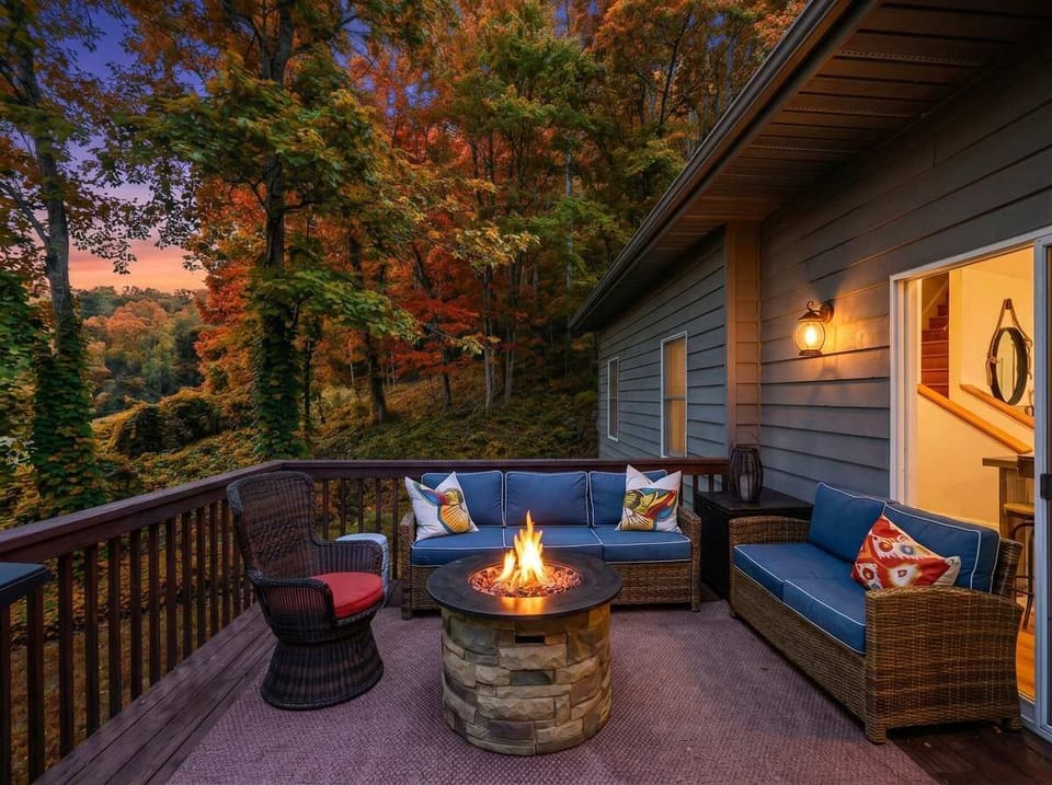 Golden hour on the deck, fire glowing, forest all around — this is exactly what a getaway should feel like.