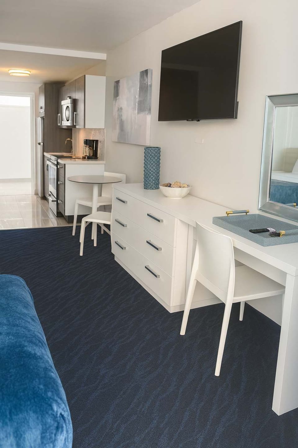 Bright and open studio featuring a sleek kitchenette, modern furnishings, and a cozy layout designed for comfort and style.