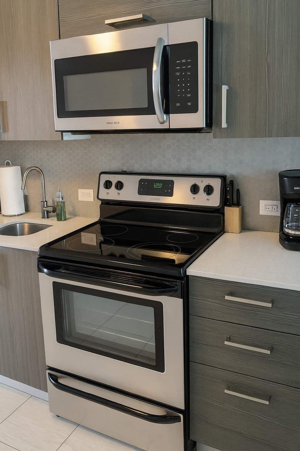 Modern kitchen with sleek stainless-steel appliances, stylish backsplash, and bright countertops—perfect for cooking during your stay.