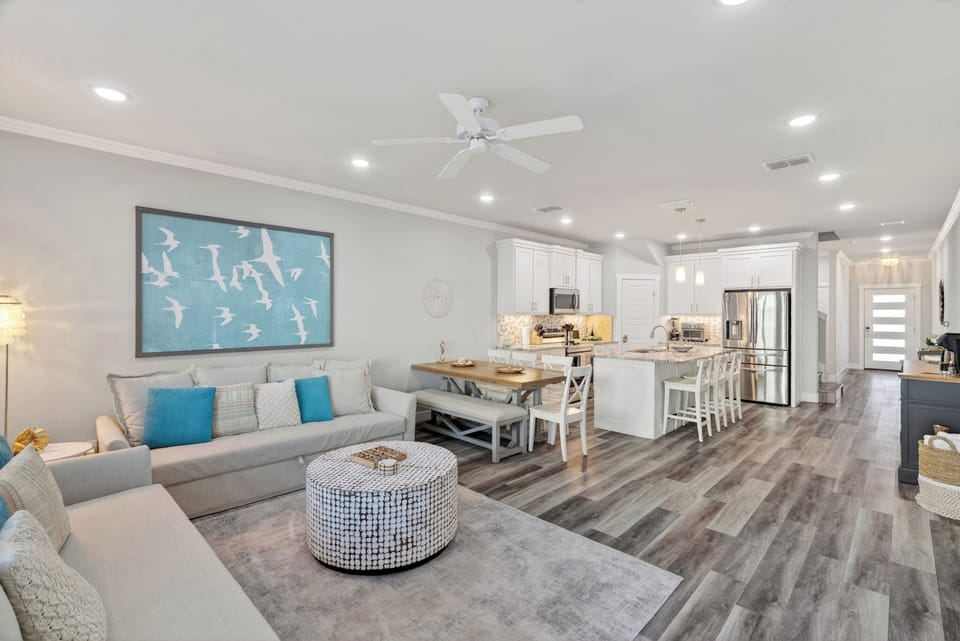 Another view of the spacious living area, showcasing the premium wood-look flooring and recessed lighting throughout.