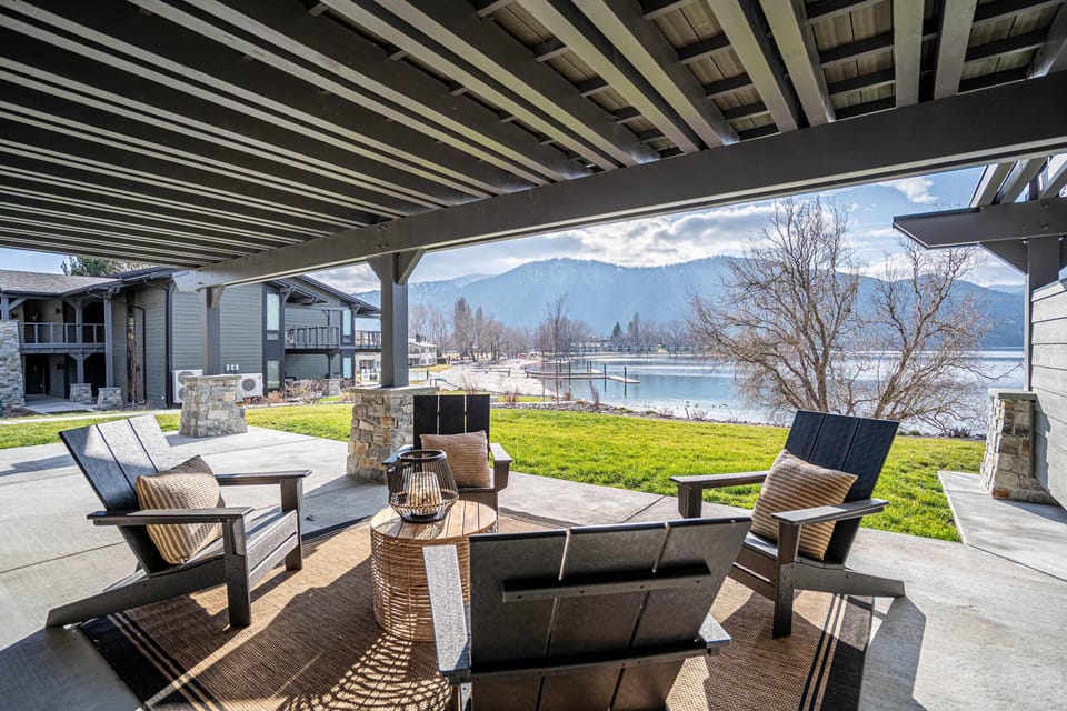 Relax in the shade on a spacious, covered outdoor patio featuring comfortable seating and picturesque mountain backdrops.