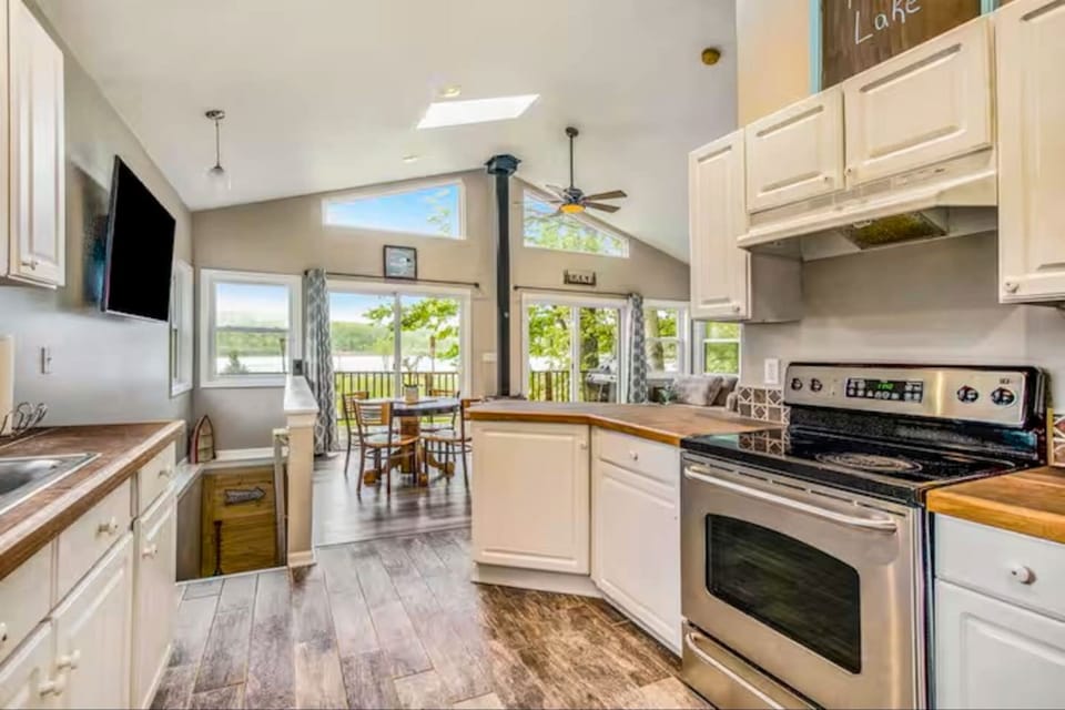 Beautiful view of the kitchen and living area. The upper deck is seen here overlooking the lake. On the deck is plenty of seating area and grilling space