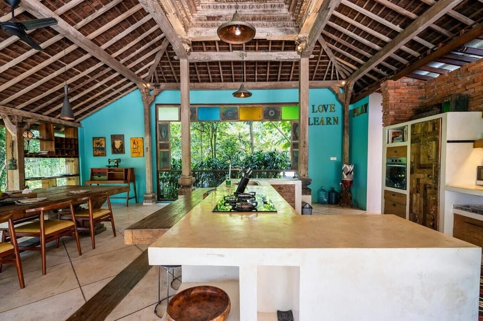 A vibrant dining area with colorful walls, a large wooden table, and comfortable seating. The space is perfect for enjoying meals with family and friends in a lively setting.
