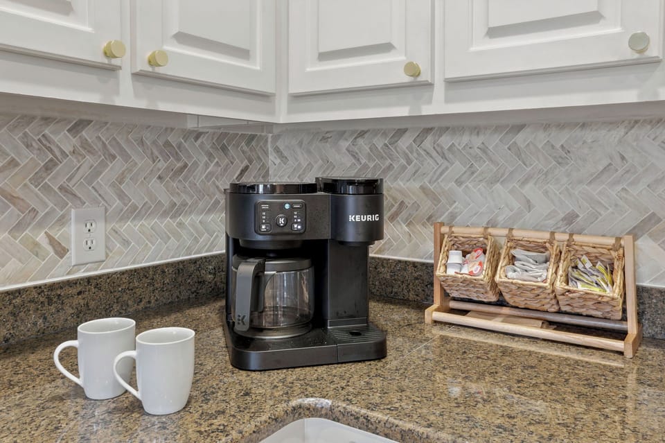 Inviting kitchen coffee station with Keurig, granite counters, and stylish tile
