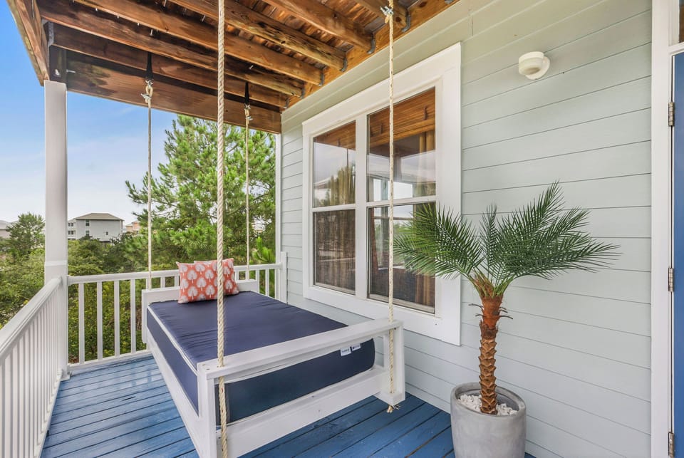 Covered porch with swing daybed and breezy coastal charm