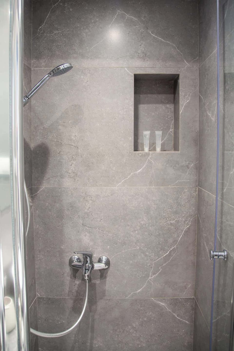 A walk in shower with grey tiling and a clean modern finish for a fresh start or end to the day.