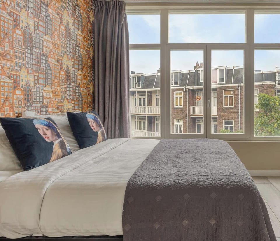 A peaceful tree-lined street surrounded by the unmistakable architecture of Amsterdam.