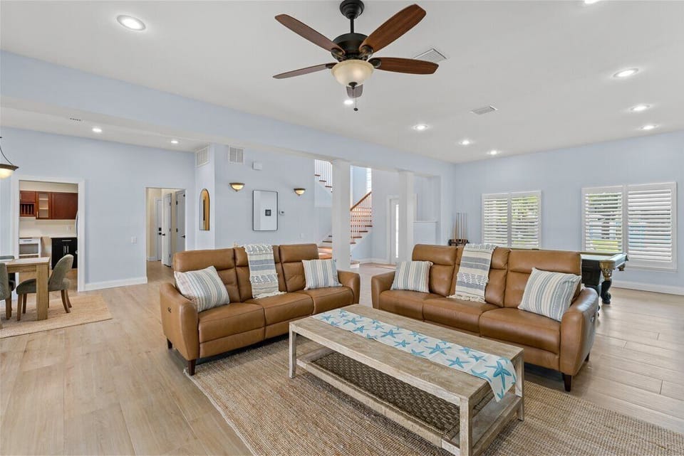 The bright and airy living room offers the perfect place to unwind after a day at the beach, complete with comfortable seating and serene waterfront scenery right outside the windows.