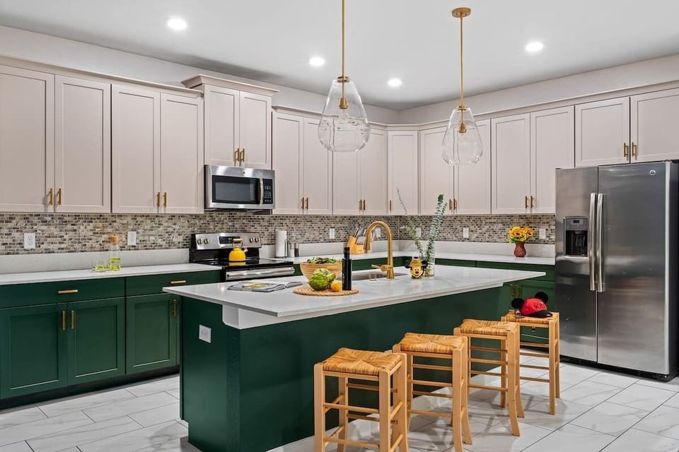 ️✨ Cook & dine in style! This modern kitchen features elegant two-tone cabinets, gold accents, and a spacious island with seating. Fully equipped for all your culinary needs  Perfect for gatherings, morning coffee, and homemade meals! ‍