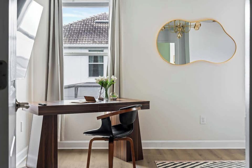  Find your focus in this elegant workspace! A sleek wooden desk, modern chair, and bright natural light create the perfect setting for work or creativity. Whether you're journaling, working remotely, or just unwinding, this space has you covered. 