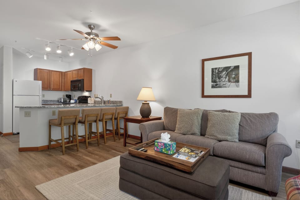 Step into your cozy open-concept retreat where the kitchen flows seamlessly into the living area—perfect for unwinding after a day of adventure. Enjoy home-cooked meals at the breakfast bar or relax on the plush sofa.
