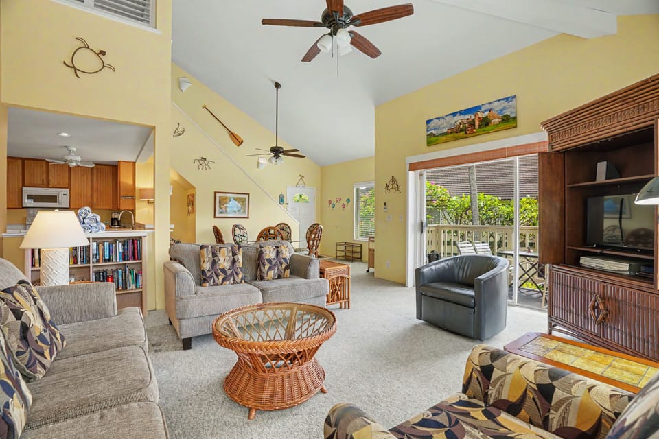 Unwind in your spacious living area with vaulted ceilings, cozy seating, and breezy access to your private balcony overlooking lush greenery.