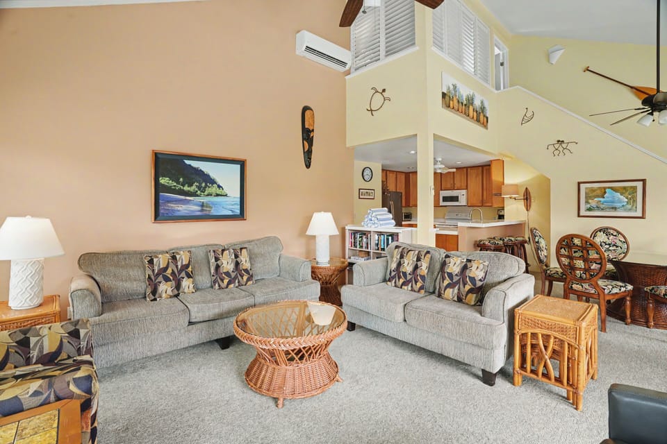 Relax in your spacious living room with vaulted ceilings, comfortable seating, tropical decor, and an open layout connecting seamlessly to the fully-equipped kitchen—perfect for your island getaway.