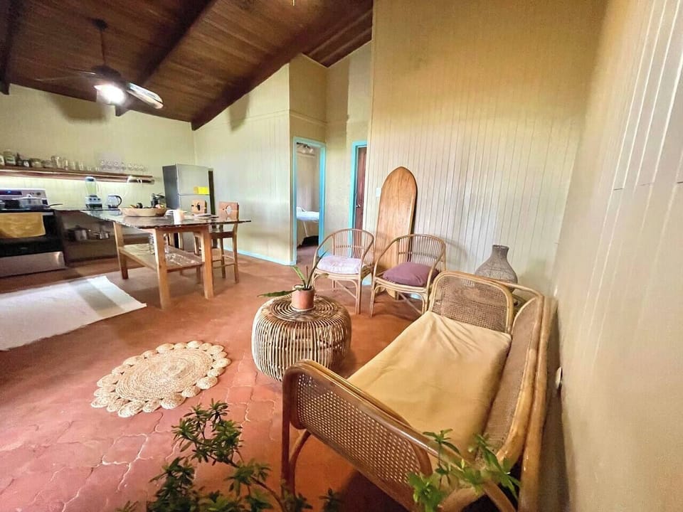 Living room space with kitchen, you can see the ocean from the chairs and relax on the couch.