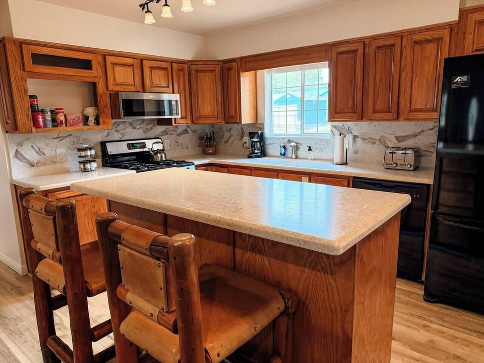 Prepare favorite family recipes in the well-stocked kitchen featuring ample workspace and mountain cabin charm
