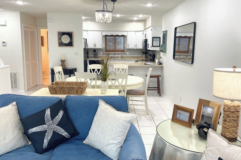 Move through the main level in one open sweep — kitchen, dining, and living connected with Gulf light all the way through.