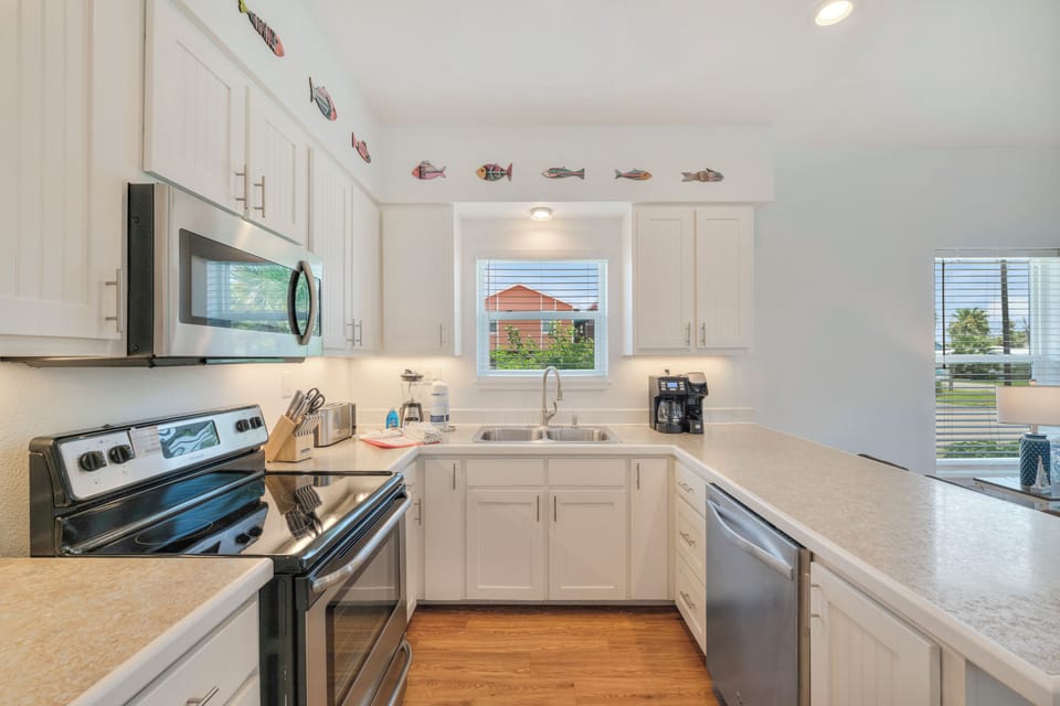 A bright, fully equipped kitchen invites you to prepare meals with modern appliances, ample counter space, and charming coastal details that make you feel right at home.