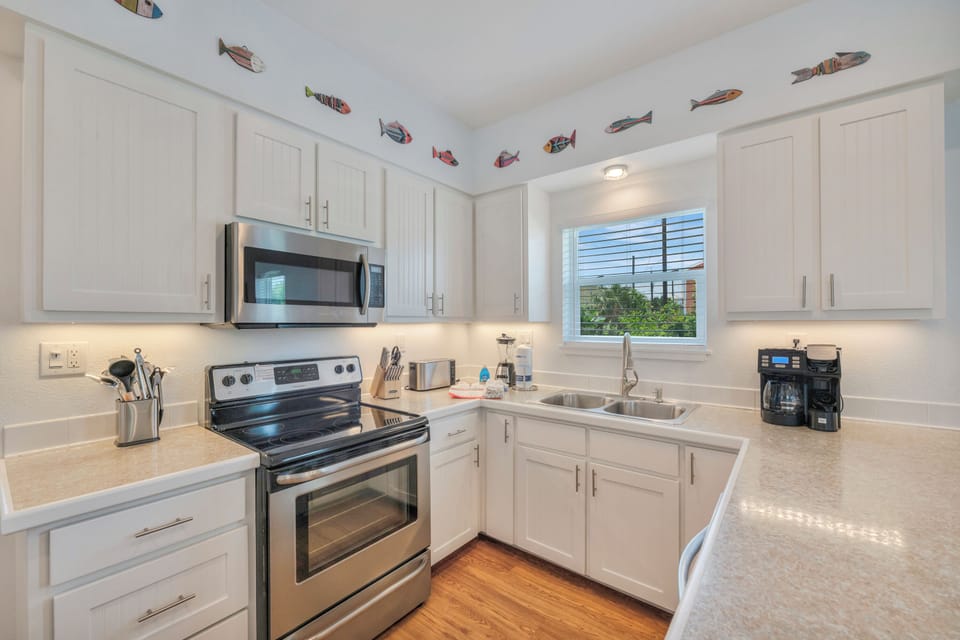 Prepare your favorite meals in this bright, fully-equipped kitchen featuring modern appliances, ample counter space, and charming coastal décor that adds a playful, beachy vibe to your stay.