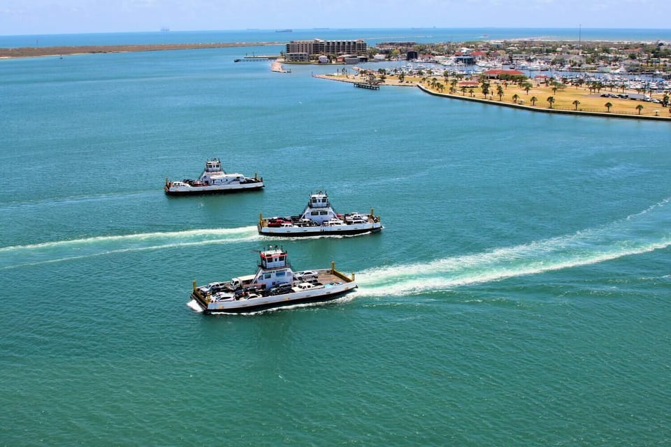 Aerial view captures three ferry boats crossing turquoise waters near a coastal town with sandy beaches and waterfront development.