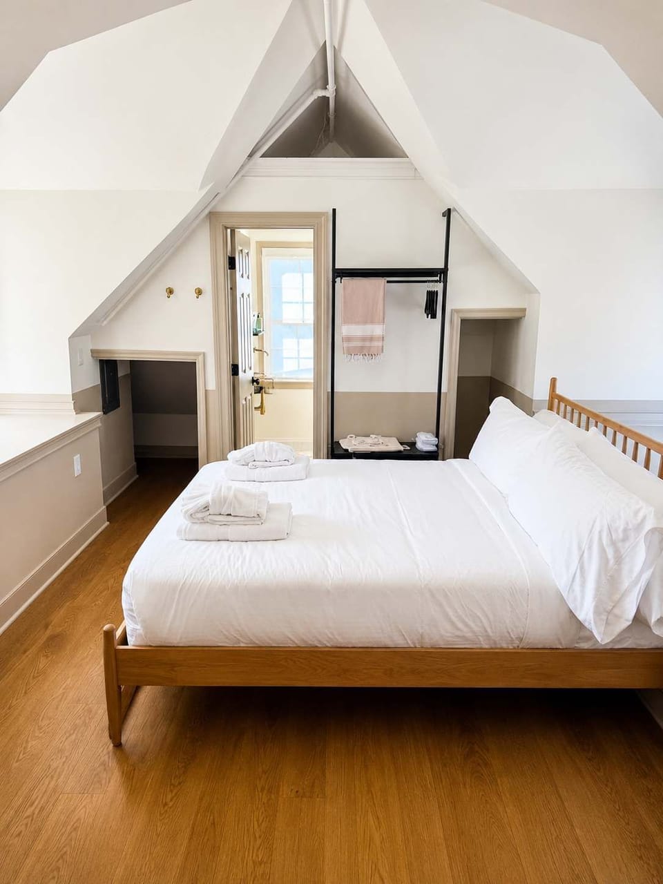 Relax in a cozy boutique bedroom featuring premium linens, charming architectural details, and a peaceful atmosphere for a restful stay.