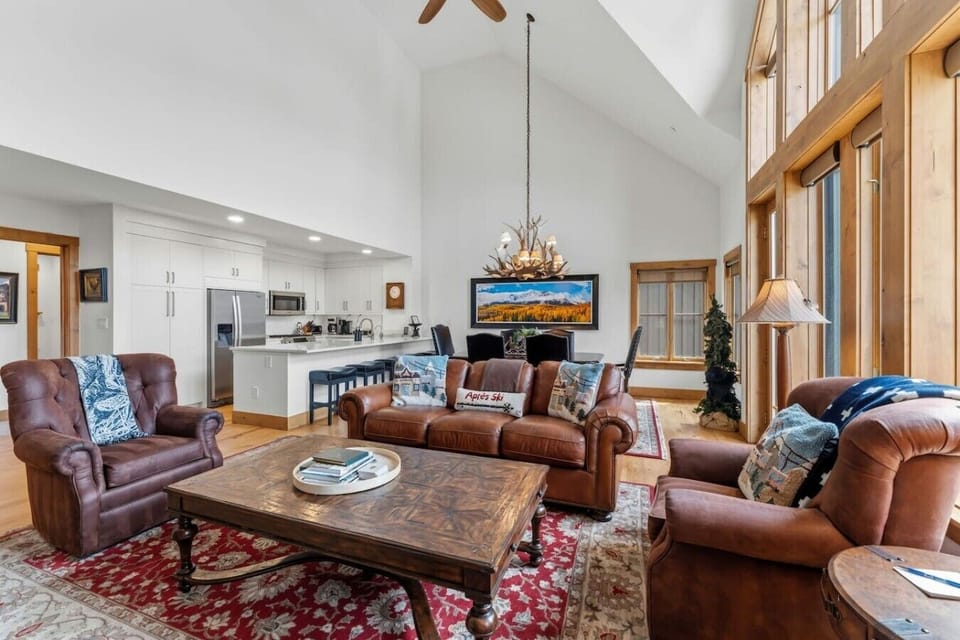 Living room with soaring ceilings, large windows, gas fireplace, and Smart Tv
