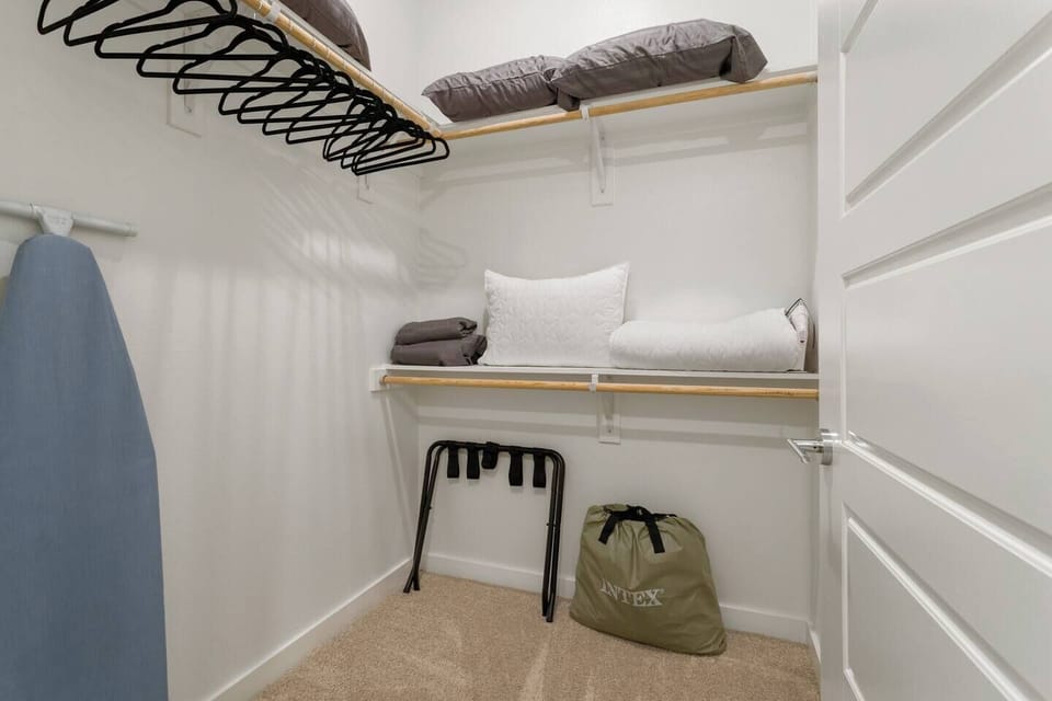 Walk in closet with Extra blankets, pillows Luggage rack, hangers, ironing board and iron to help while you travel.