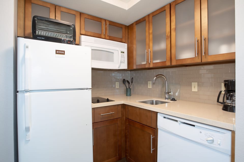 Modern kitchen equipped with essential appliances and ample storage.