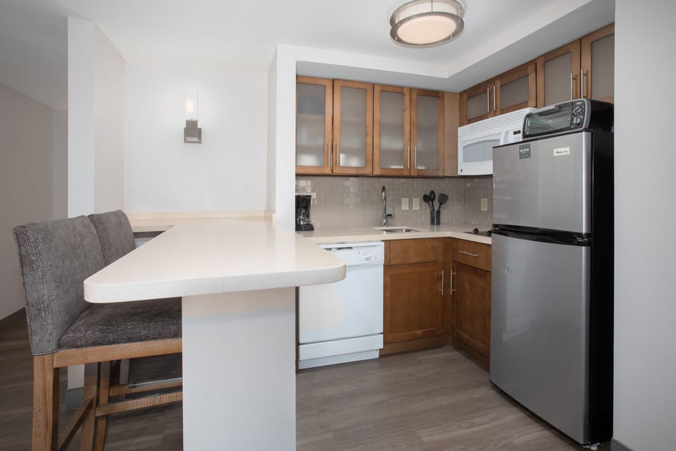 Kitchen with modern appliances and breakfast bar seating.