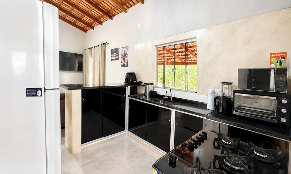 Recanto Santa Bárbara com Piscina - Pirenópolis | Private kitchen | Fridge, microwave, cookware/dishes/utensils, dining table