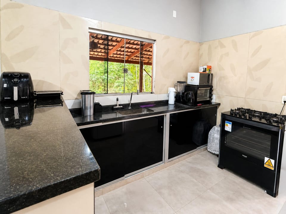 Recanto Santa Bárbara com Piscina - Pirenópolis | Private kitchen | Fridge, microwave, cookware/dishes/utensils, dining table