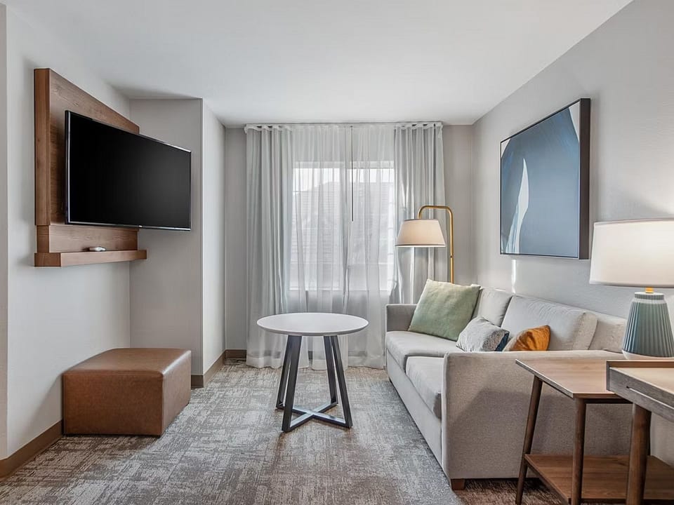 Relax in your cozy living area, featuring a plush sofa and a flat-screen TV for entertainment.