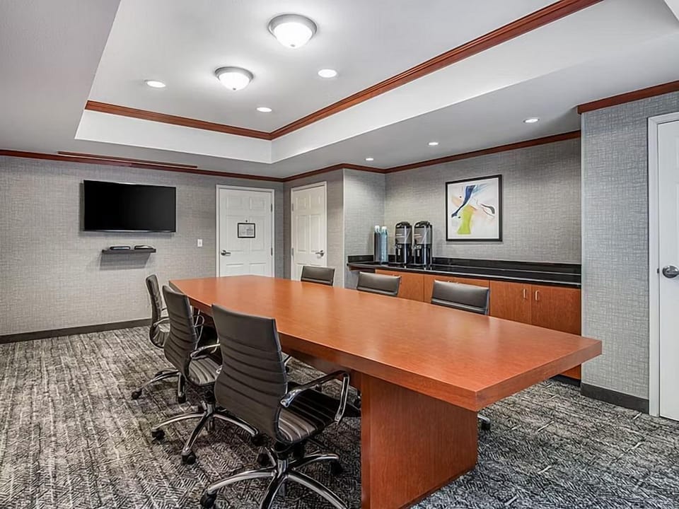 Gather for discussions in a professional meeting room, complete with a large table and A/V equipment.