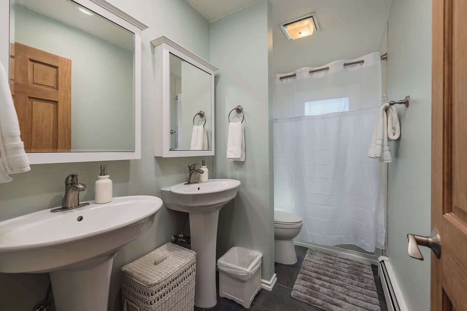 Full bathroom with a large tub, shower and 2 sinks.