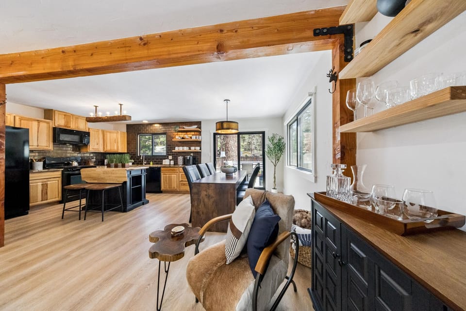 Dining area with dark wood table, black leather chairs, and sliding glass door to backyard patio.