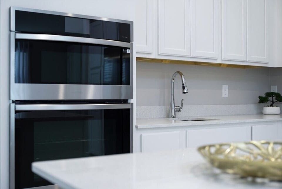 Fully equipped kitchen with stainless steel appliances, including built-in ovens for convenient cooking