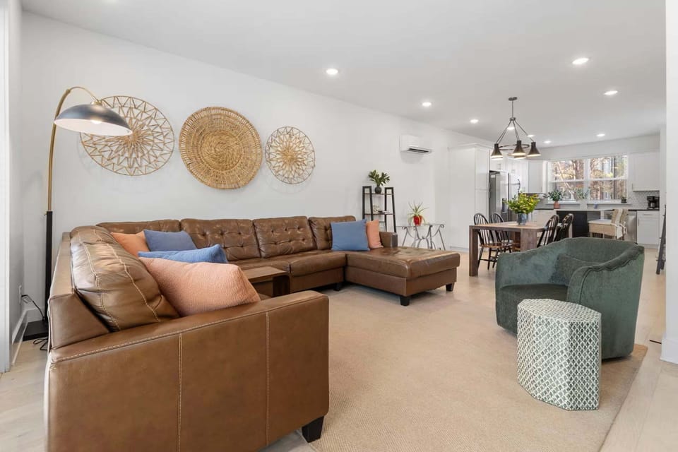 Living area with stylish leather couch and seating for TV viewing + sleeper sofa and patio access (sleeps 2)