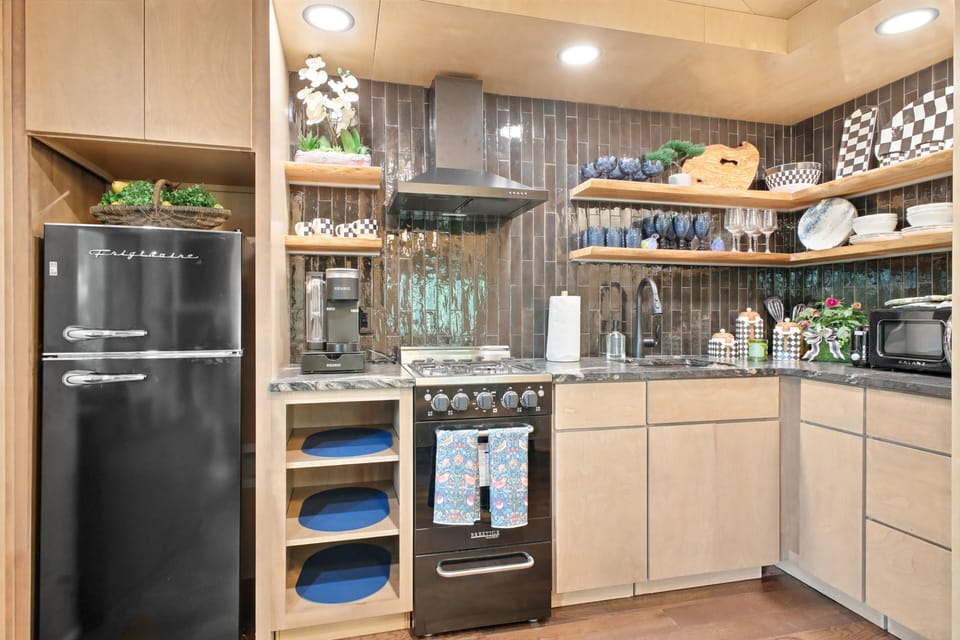 Whip up mountain memories in this stylish modern kitchen, featuring a fun retro fridge, open shelving, and everything you need to cook up a feast.