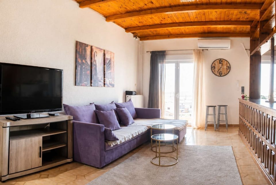 Unwind in the cozy living area with comfortable seating, TV, natural light, and direct access to the balcony. A perfect space to enjoy your morning coffee or relax after a day of sightseeing
