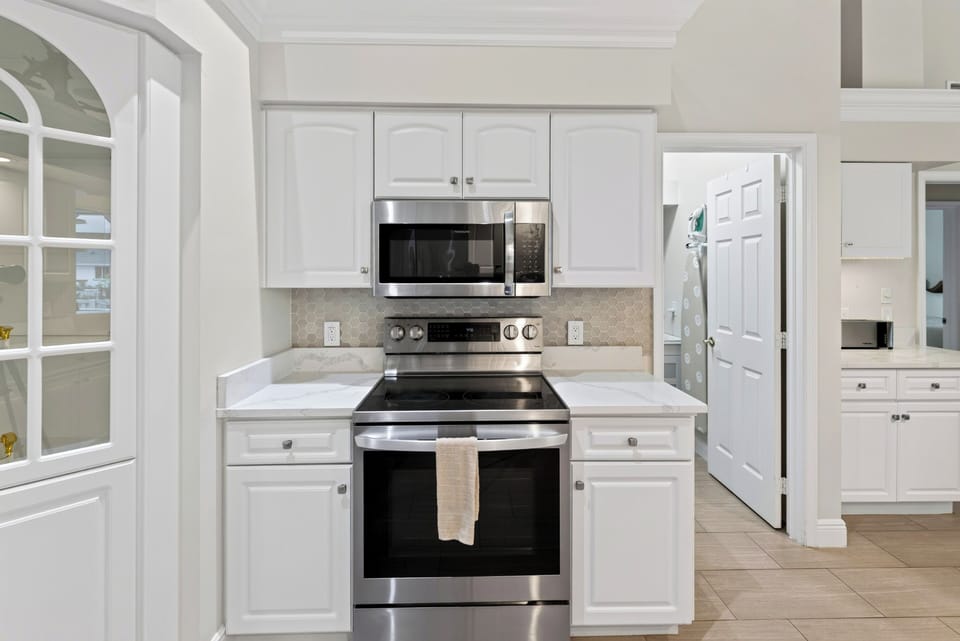 Fully equipped kitchen workspace highlighting stainless steel appliances, smooth countertops, and ample storage.