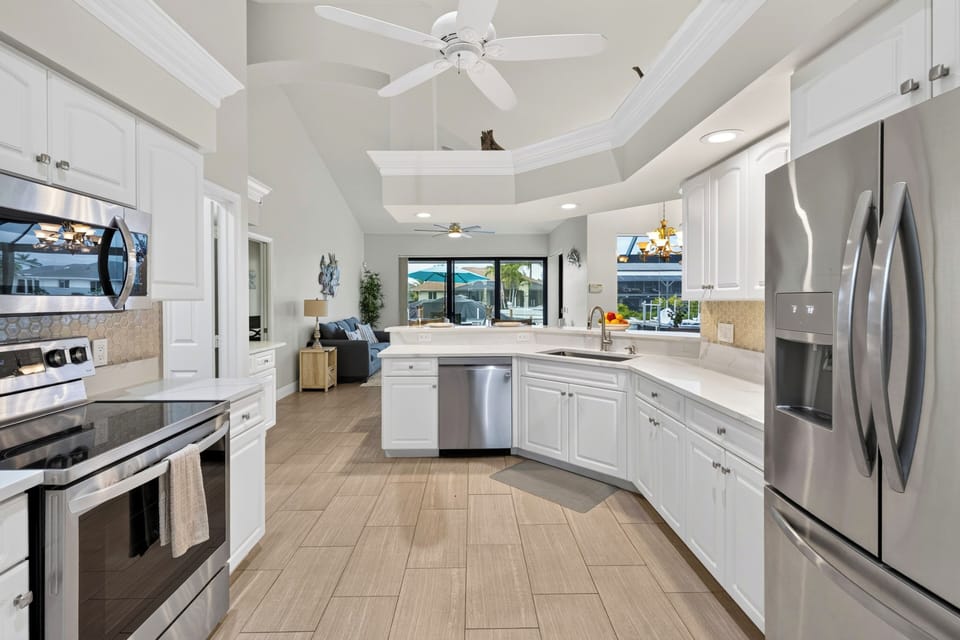 Broad perspective of the wrap-around kitchen workspace, highlighting the bright layout and functional flow.